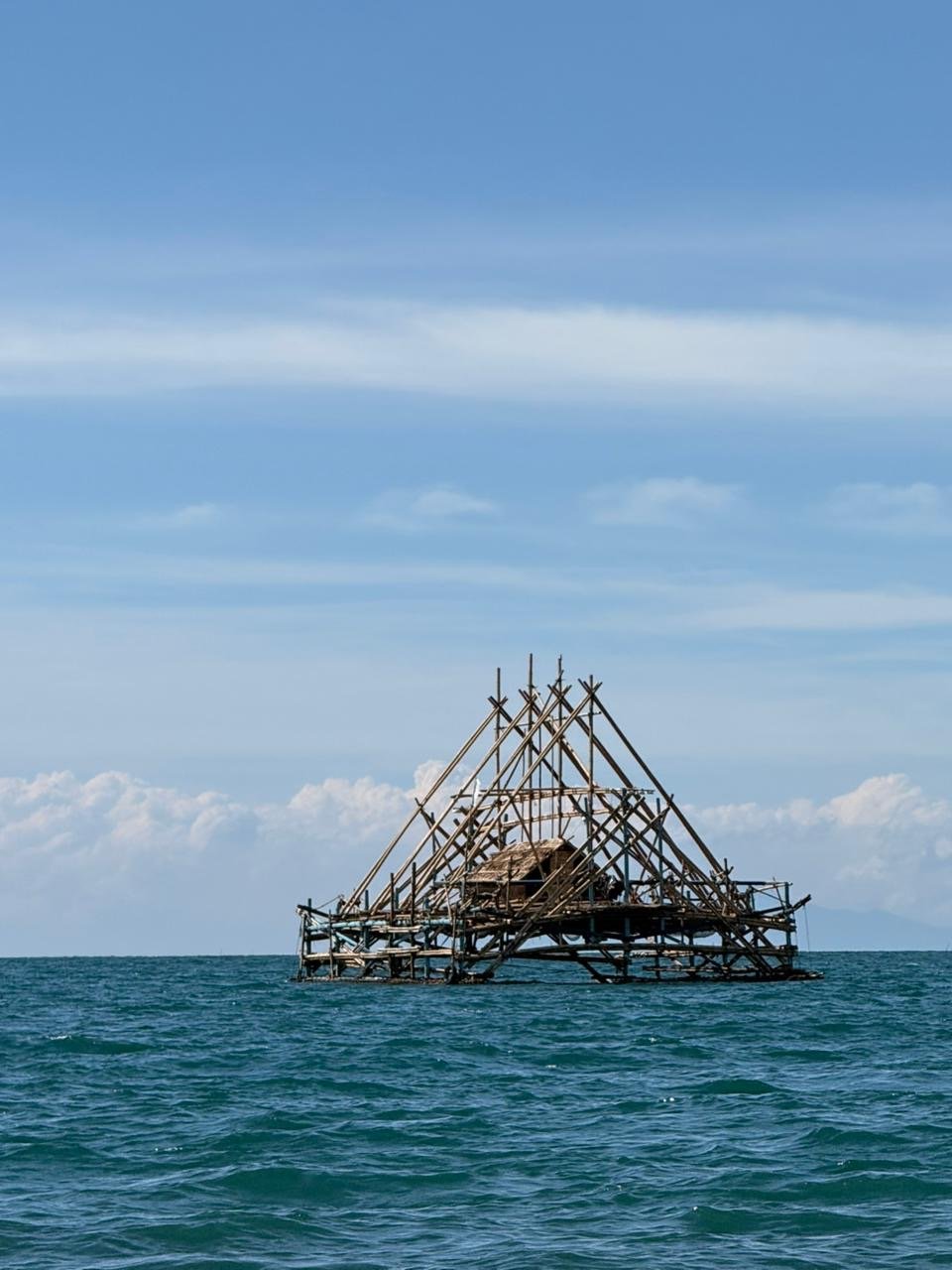 A traditional bamboo bagan fishing platform standing alone in the strait
